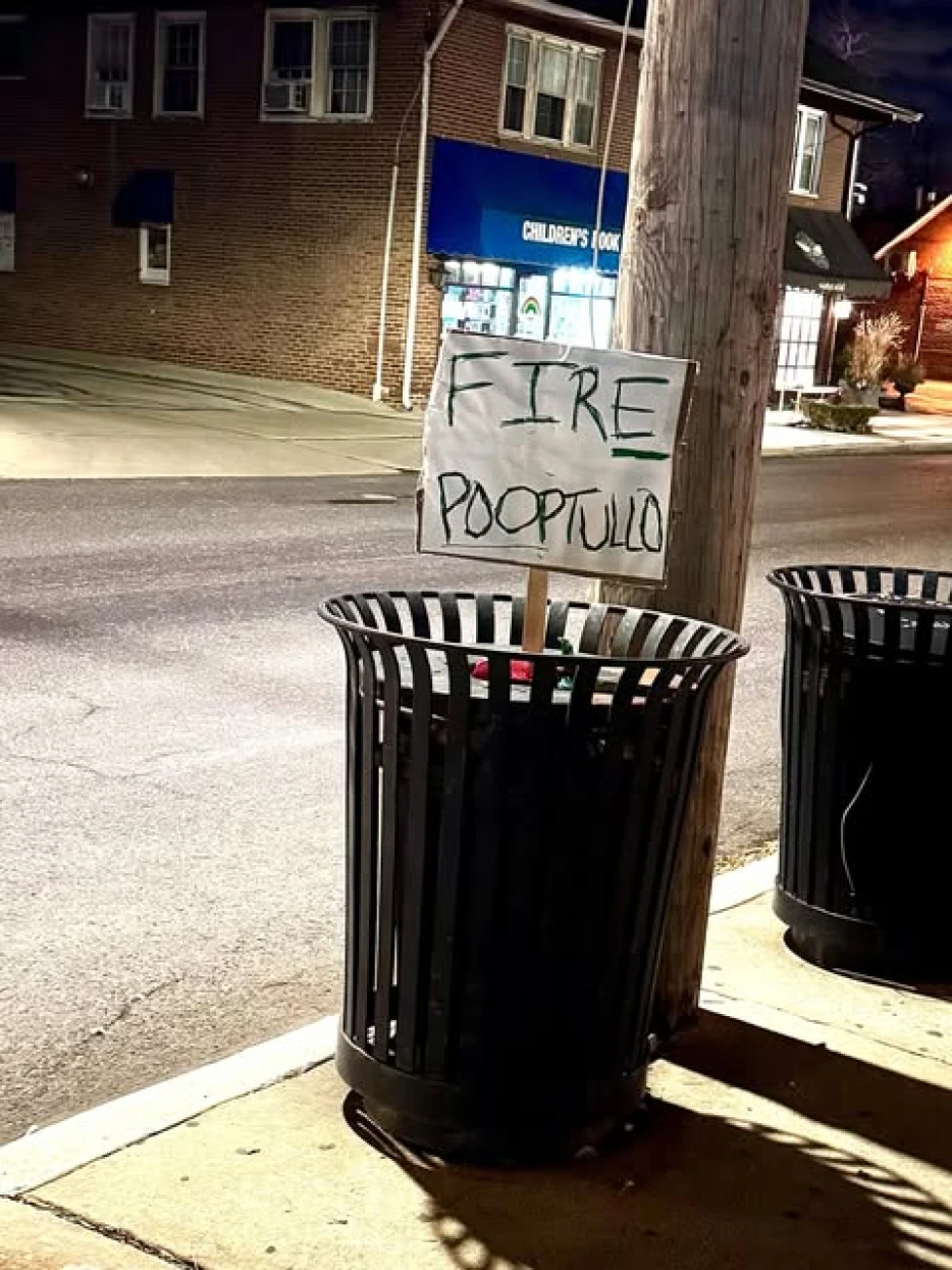 Nothing to See Here, Just a “Fire Pooptullo” Sign Sticking Out of a Trash Can in Front of a Main Line Children’s Book Store